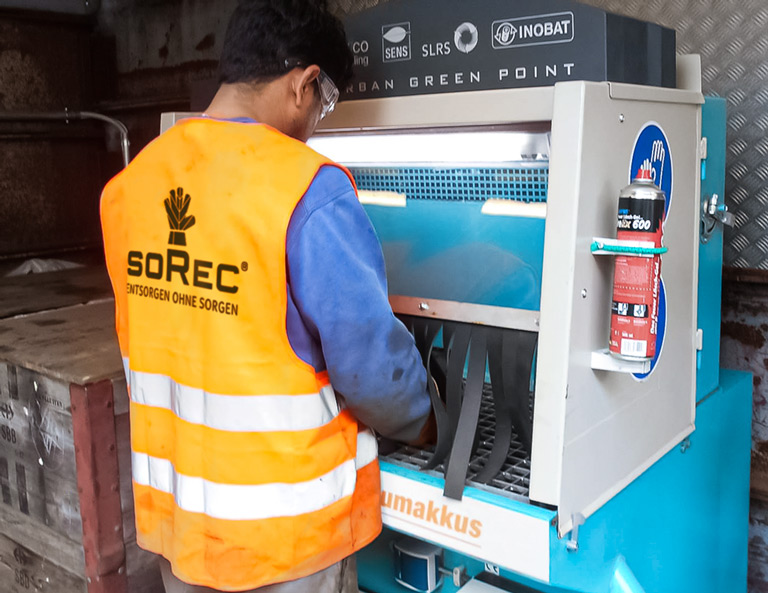 soRec-Mitarbeiter beim sicheren Entsorgen und Recyceln von Lithiumakkus aus alten Smartphones