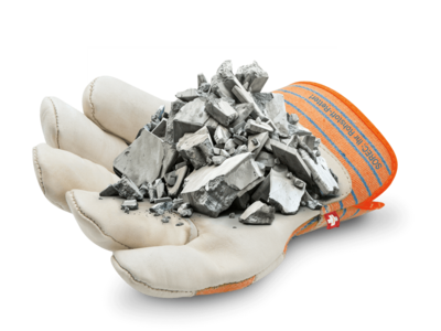Ein weisser Arbeitshandschuh mit orangefarbenen Streifen liegt geöffnet da, in seiner Handfläche befindet sich ein Haufen silberner Metallschrottteile.